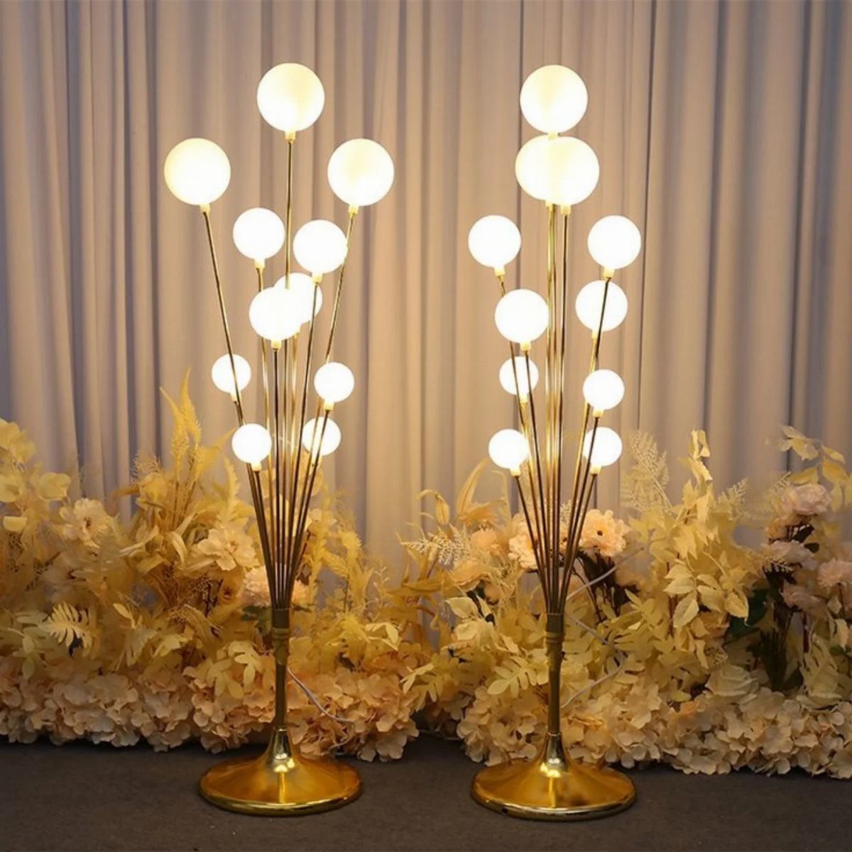 Wedding Mood Board Ideas: 39 Styles from Celestial to Coastal 29 Two gold globe floor lamps standing among cream floral arrangements against draped curtains.