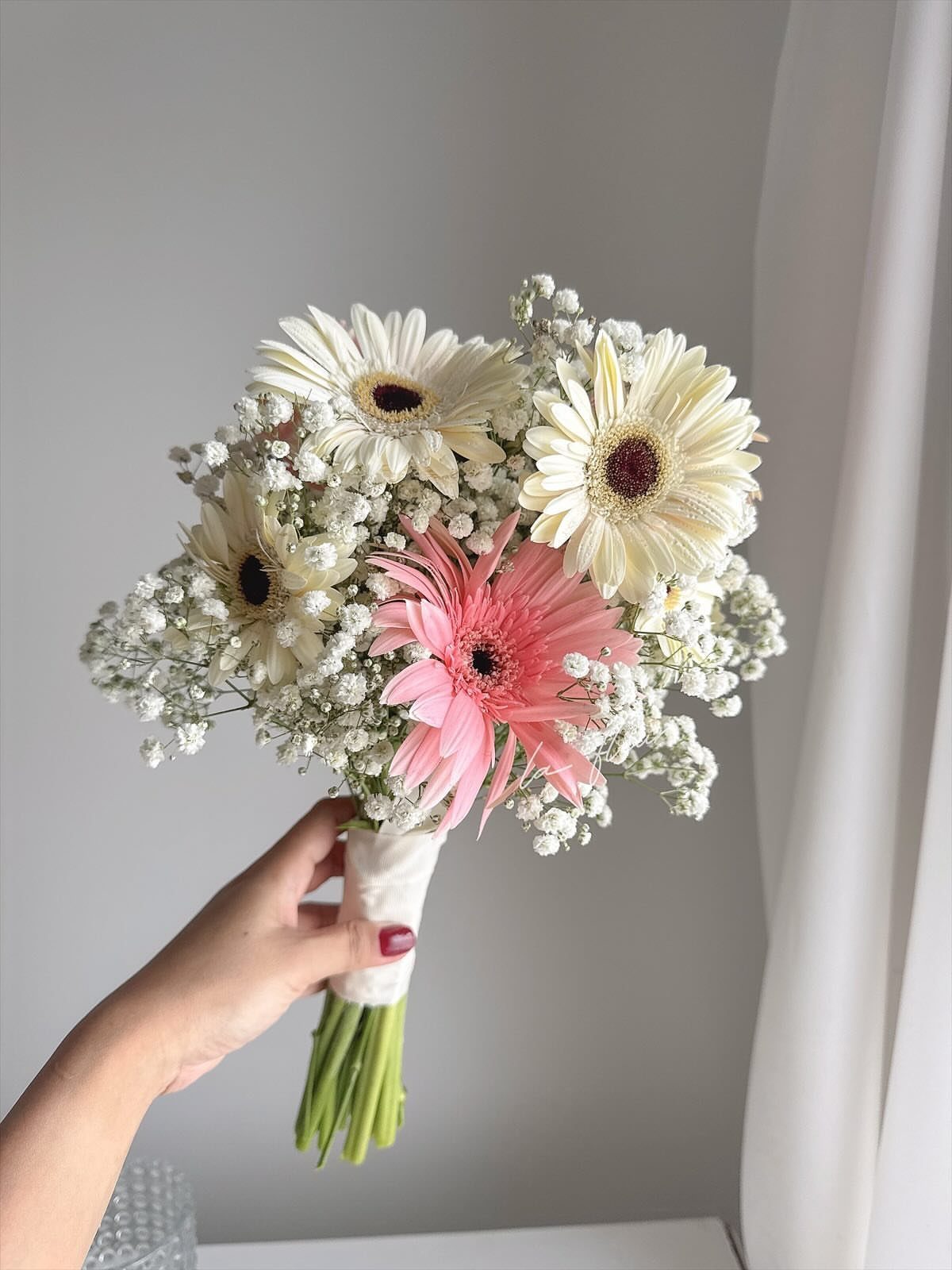 Wedding Mood Board Ideas: 39 Styles from Celestial to Coastal 39 Bridal bouquet with white and pink gerbera daisies and baby's breath held by hand.