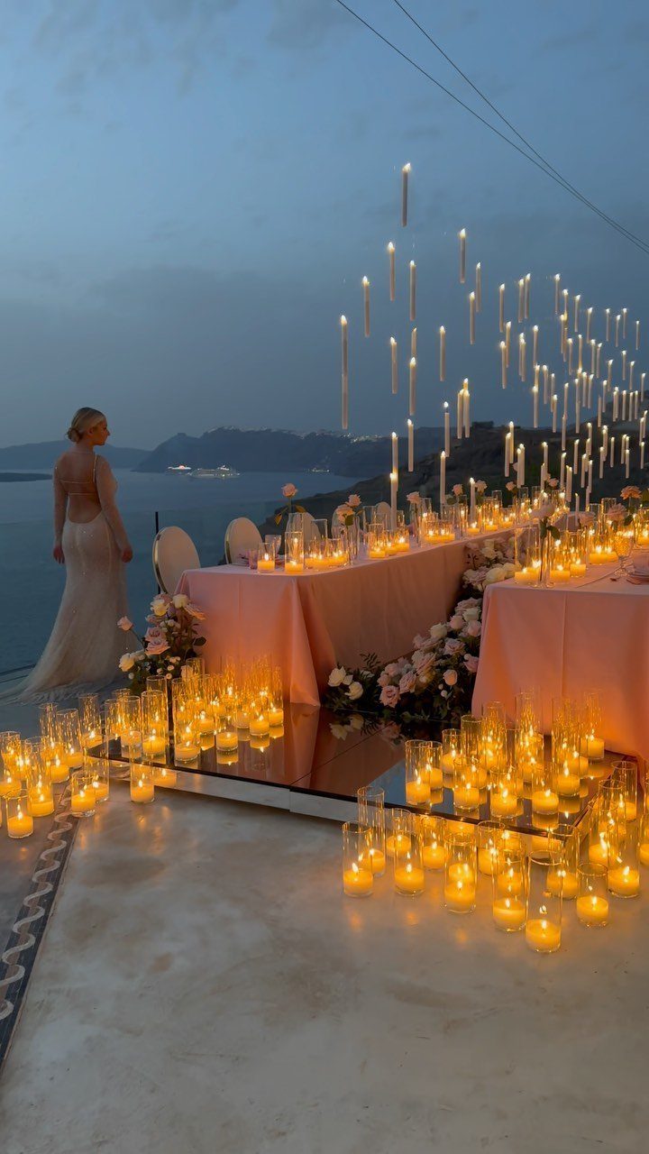 Wedding Mood Board Ideas: 39 Styles from Celestial to Coastal 33 Bride standing by a romantic dinner table with floating candles and pink linens.
