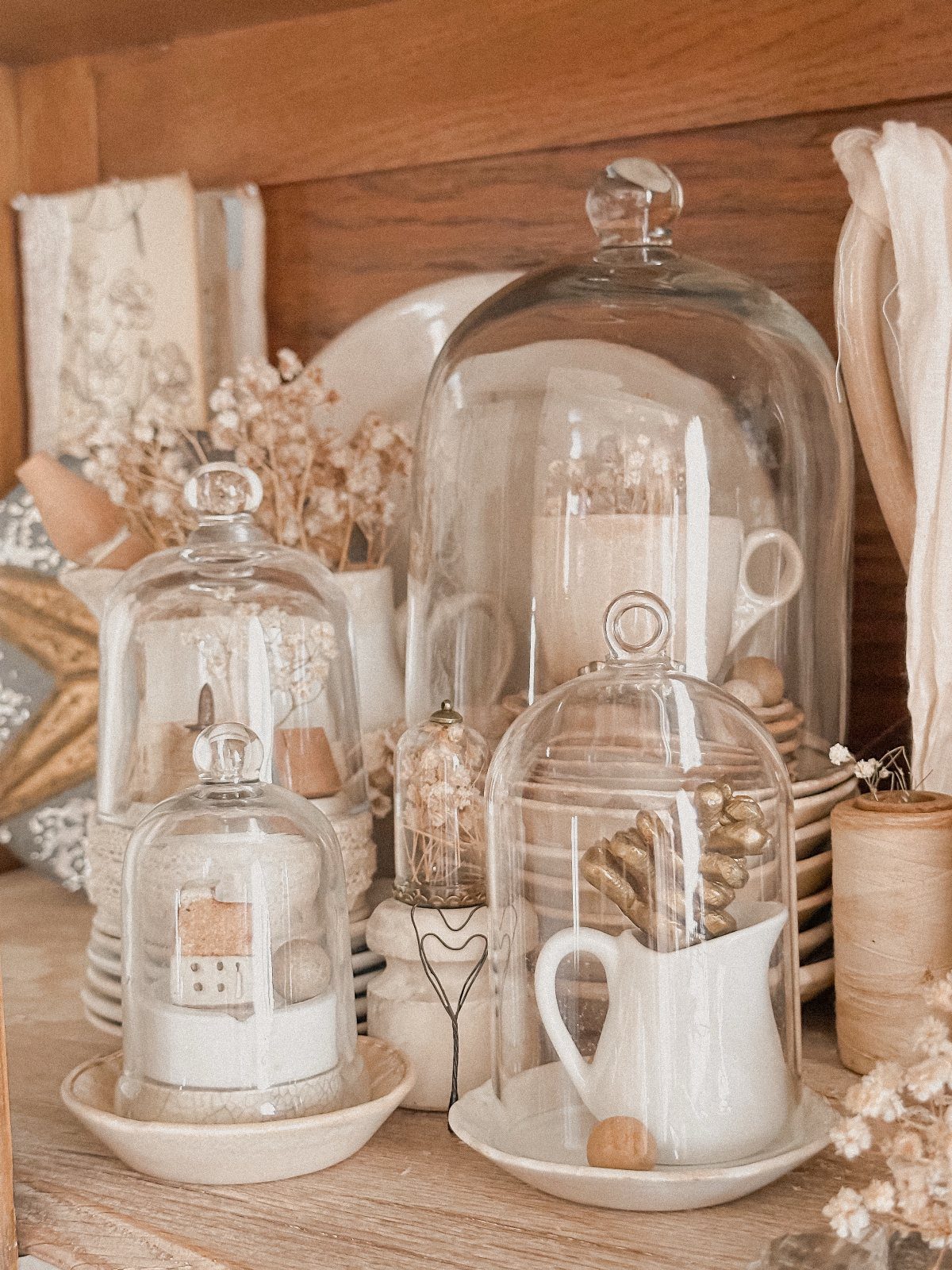 Wedding Mood Board Ideas: 39 Styles from Celestial to Coastal 6 Glass cloches covering a white pitcher and miniature house on a wooden shelf.