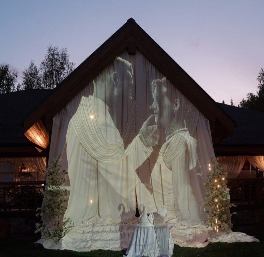 Wedding Mood Board Ideas: 39 Styles from Celestial to Coastal 2 Large projection of a couple on white drapes under a peaked roof at dusk